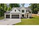 A modern two story farmhouse, with white siding, dark trim, and a wide driveway at 1870 Twin Branch Dr, Marietta, GA 30062