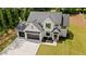 Elevated view of modern two-story farmhouse with light brick, dark trim, three car garage, and green yard at 1870 Twin Branch Dr, Marietta, GA 30062
