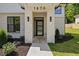 Stylish front entry featuring a black modern door, sconce lighting, and clean landscaping at 1870 Twin Branch Dr, Marietta, GA 30062