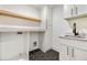 Well-lit laundry room with custom cabinets, floating shelves, granite countertop, and stylish hexagonal tile floor at 1870 Twin Branch Dr, Marietta, GA 30062