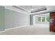 Spacious carpeted main bedroom featuring a tray ceiling, ceiling fan and sitting area at 5882 Riverstone Cir # 15, Atlanta, GA 30339