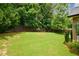 Spacious backyard featuring a lush lawn, mature trees, and privacy fencing at 9013 Aldbury Dr, Locust Grove, GA 30248