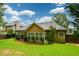 Backyard view of house showing patio with furniture set, manicured lawn and flower bed at 9013 Aldbury Dr, Locust Grove, GA 30248