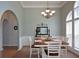 Classic dining room with a wooden table, decorative chandelier, and large arched windows at 9013 Aldbury Dr, Locust Grove, GA 30248