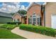 Exterior shot of a charming home with manicured hedges, a brick facade, and a two-car garage at 9013 Aldbury Dr, Locust Grove, GA 30248