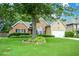 Home featuring a large tree in the front yard, brick and siding exterior, and manicured landscaping at 9013 Aldbury Dr, Locust Grove, GA 30248
