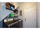 Functional laundry room with washer, dryer, shelving, and storage for laundry supplies at 9013 Aldbury Dr, Locust Grove, GA 30248