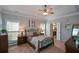 Spacious main bedroom with a tray ceiling, two windows, and an attached bathroom at 9013 Aldbury Dr, Locust Grove, GA 30248