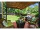 Patio area with wicker furniture, awning, and grill for outdoor relaxation at 9013 Aldbury Dr, Locust Grove, GA 30248