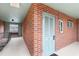 View of an outside condo unit, featuring a numbered door, brick wall, and a well-lit hallway with a bench at 91 Rumson Rd, Atlanta, GA 30305