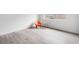 An interior living space with modern grey flooring, bright white walls, and an orange chair near a window at 91 Rumson Rd, Atlanta, GA 30305