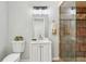 Bright bathroom with white cabinets, a clear glass shower with tiled walls, and a decorative light fixture at 300 Rocky Cove Trl, Lawrenceville, GA 30044