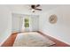 Cozy bedroom featuring hardwood floors, a ceiling fan, and natural light at 300 Rocky Cove Trl, Lawrenceville, GA 30044