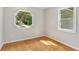 A bright room with hardwood floors is illuminated by the light coming through an octagonal window and another standard window at 300 Rocky Cove Trl, Lawrenceville, GA 30044