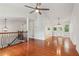 Bright living room with hardwood floors, vaulted ceilings, a ceiling fan, and staircase with decorative railing at 300 Rocky Cove Trl, Lawrenceville, GA 30044