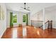 Bright living room with hardwood floors, vaulted ceilings, a ceiling fan, and staircase with decorative railing at 300 Rocky Cove Trl, Lawrenceville, GA 30044
