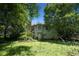 View of the backyard featuring a two-story house with a door and window among lush green foliage at 501 Textbook Ct, Lawrenceville, GA 30044