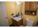 Compact bathroom with a wooden vanity, white sink, matching medicine cabinet, and a nearby toilet at 501 Textbook Ct, Lawrenceville, GA 30044