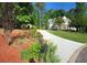 The driveway leads to a charming two-story home surrounded by trees, landscaping, and flowering bushes at 811 Millvale Pl, Lawrenceville, GA 30044