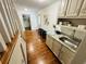 Hallway featuring hardwood floors, stairs, and a convenient wet bar area at 1931 Amber Dawn Way, Lawrenceville, GA 30043