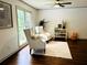 Bright living room with hardwood floors and elegant armchairs by large windows at 1931 Amber Dawn Way, Lawrenceville, GA 30043