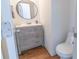 Modern powder room with a gray vanity, round mirror, and stylish fixtures at 1931 Amber Dawn Way, Lawrenceville, GA 30043