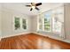 Bedroom featuring hardwood floors, a ceiling fan, and large windows dressed with translucent curtains at 242 12Th Ne St # 1A, Atlanta, GA 30309