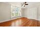 Bright bedroom featuring hardwood floors, ceiling fan, and large windows with white curtains at 242 12Th Ne St # 1A, Atlanta, GA 30309