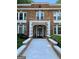 Brick building exterior with white accents, arched entryway, and manicured landscaping at 242 12Th Ne St # 1A, Atlanta, GA 30309