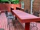 Outdoor deck with a large picnic table and chair set surrounded by a red fence at 242 12Th Ne St # 1A, Atlanta, GA 30309