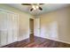 A bedroom with tan walls, hardwood floors, and white closet doors at 3963 Holland Ct, Douglasville, GA 30135