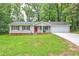 Charming single-story home featuring a red front door, attached garage, and a well-manicured lawn at 3963 Holland Ct, Douglasville, GA 30135