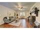 Open living room with hardwood floors, ceiling fan, and a white painted brick fireplace at 3963 Holland Ct, Douglasville, GA 30135