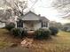A cute bungalow with a small porch and mature bushes sits on a small lot at 5111 Newark Ave, Clarkdale, GA 30111
