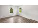 Bedroom featuring hardwood floors and two windows with natural light at 6932 Eunice Dr, Riverdale, GA 30274