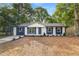 Charming exterior with a well-manicured lawn, fresh exterior paint and complementary landscaping at 6932 Eunice Dr, Riverdale, GA 30274