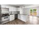 A modern kitchen featuring stainless steel appliances, new white cabinets, and a granite countertop island at 6932 Eunice Dr, Riverdale, GA 30274