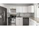 Bright kitchen with stainless appliances, granite countertops, and stylish white cabinets at 6932 Eunice Dr, Riverdale, GA 30274