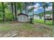 View of backyard featuring storage shed, mature trees, and well-maintained lawn at 2121 Crescentview Dr, Lawrenceville, GA 30044