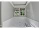 This bright bathroom features a large soaking tub and a window with beautiful views at 2121 Crescentview Dr, Lawrenceville, GA 30044