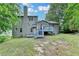 Exterior back view of home with deck, chimney and blue-painted stairs at 2121 Crescentview Dr, Lawrenceville, GA 30044