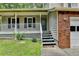 Close up of the home's welcoming covered front porch, steps, and a traditional brick facade at 2121 Crescentview Dr, Lawrenceville, GA 30044