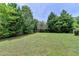 Lush backyard with mature trees, a privacy fence, and ample space for outdoor activities at 2355 Glen Chase Ln, Lawrenceville, GA 30044
