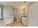 Bright bathroom featuring a soaking tub, shower, and a modern vanity with ample storage at 2355 Glen Chase Ln, Lawrenceville, GA 30044