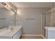 Clean bathroom with a glass-enclosed shower, spacious vanity, and neutral tile flooring at 2355 Glen Chase Ln, Lawrenceville, GA 30044