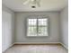 A carpeted bedroom has neutral walls and a window letting in natural light at 2355 Glen Chase Ln, Lawrenceville, GA 30044