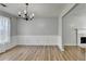 Elegant dining room featuring hardwood floors, chandelier, wainscoting, and fireplace in the background at 2355 Glen Chase Ln, Lawrenceville, GA 30044