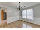 Dining area featuring chandelier, wainscoting, hardwood floors, and natural light at 2355 Glen Chase Ln, Lawrenceville, GA 30044