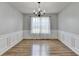 Elegant dining room with hardwood floors, wainscoting, chandelier, and large window at 2355 Glen Chase Ln, Lawrenceville, GA 30044