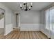 Cozy dining room with hardwood floors, wainscoting, chandelier, and a view of the hallway at 2355 Glen Chase Ln, Lawrenceville, GA 30044